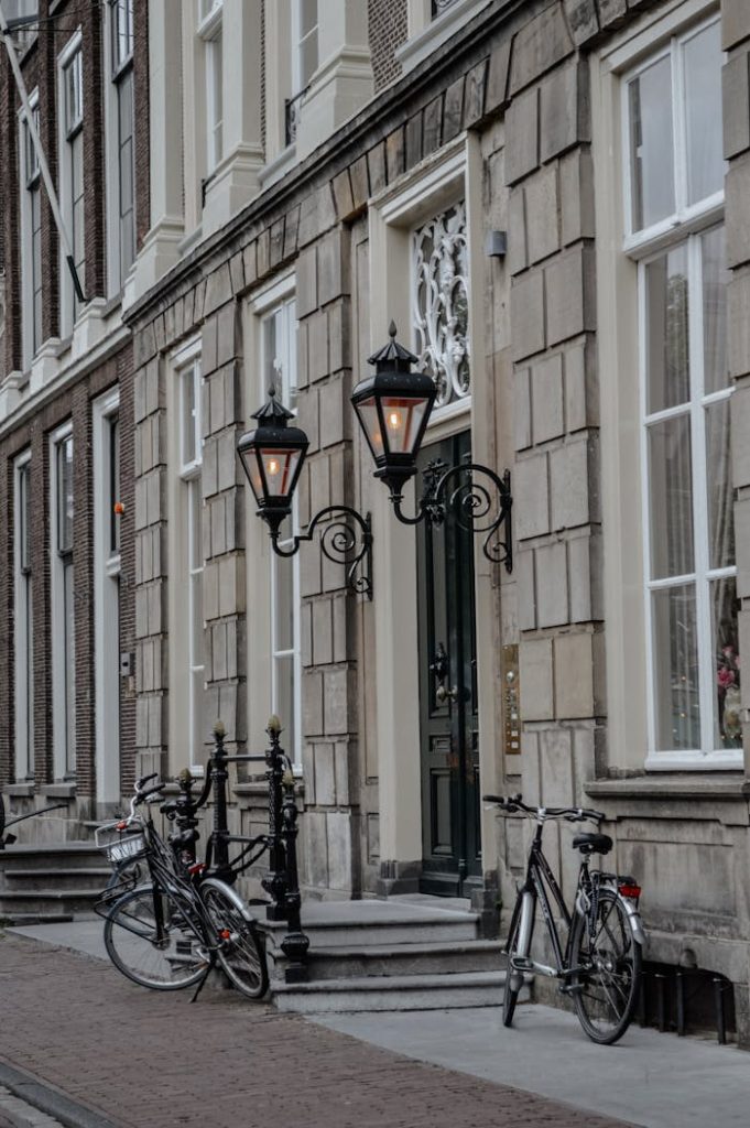 Charming narrow street in Leiden showing classic architecture with bicycles parked by vintage lamp posts.